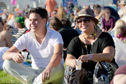 This is a picture of two people sitting down chilling at an out door festival.