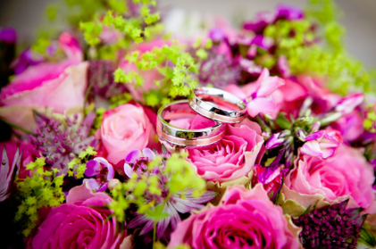 A picture of some beautiful roses and two wedding rings.